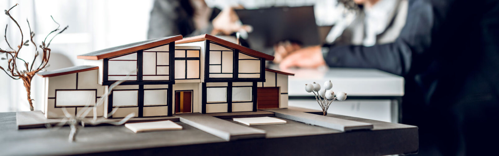 Hausmodell auf dem Schreibtisch, H&H FinanzMakler Immobilien